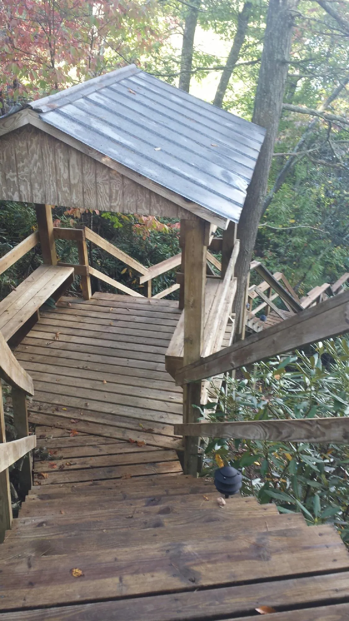 Metal roofed shelter over wooden steps on a wooded walkway — Skylight Repair & Installation work by our crew in Ashland